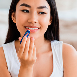 Woman using blistex MedPlus Stick lip balm